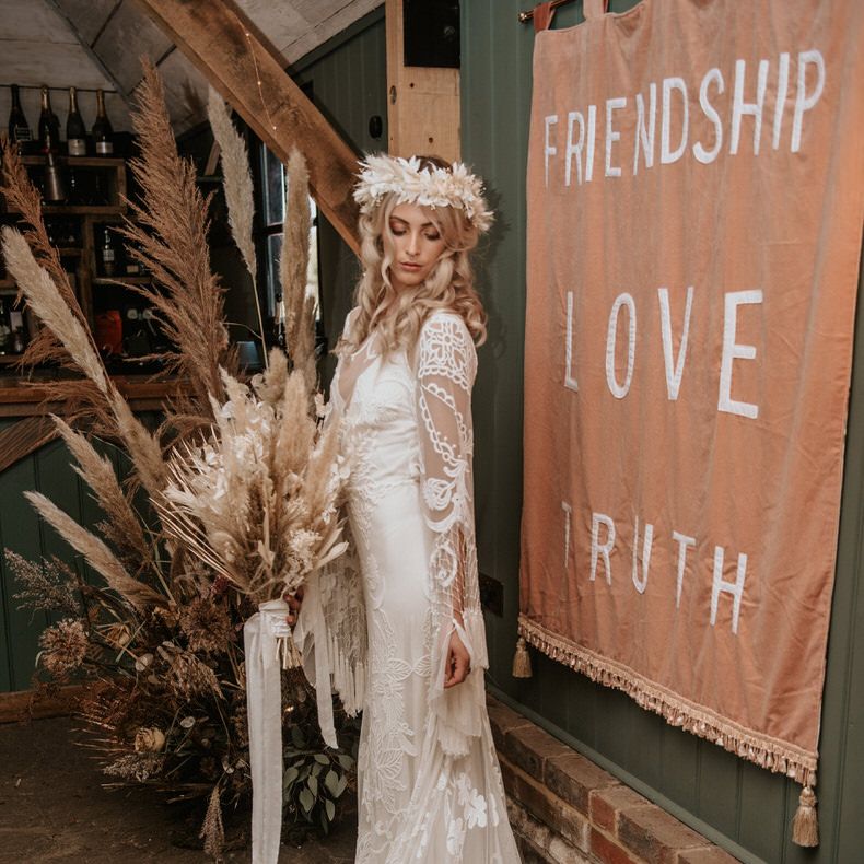 Bride stands in front of velvet wedding wall banner signage