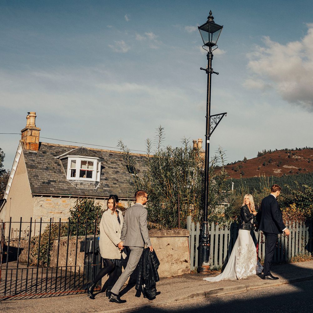 Bride & groom walk with wedding guests in Scotland