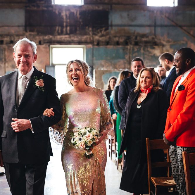 Bride walks down the aisle with her father during wedding ceremony