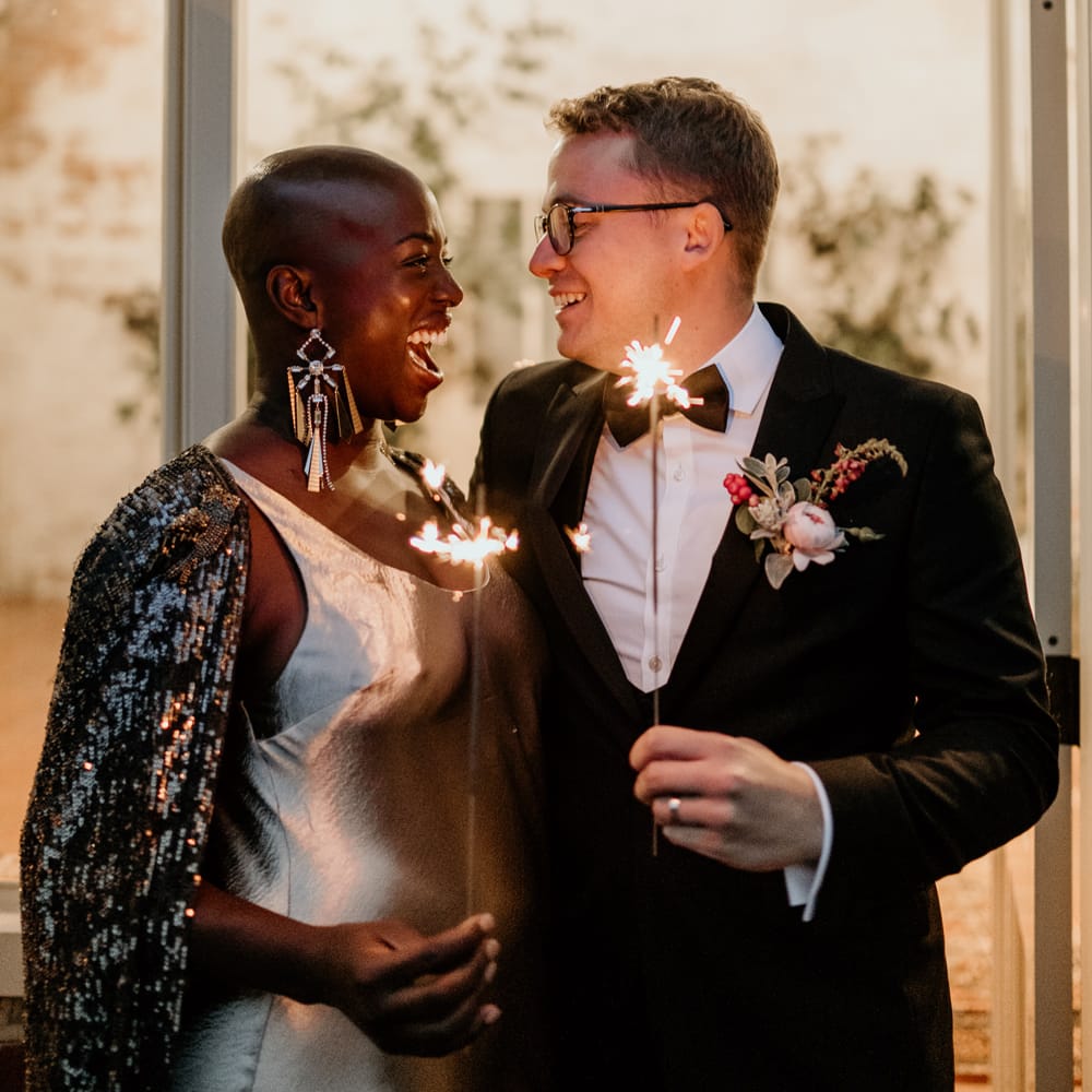 Sparkler moment with bride with alopecia wearing a black glitter bridal cape and Tilly Thomas lux statement earrings 