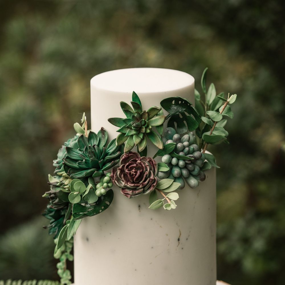 White frosted two tier cake with green floral decor