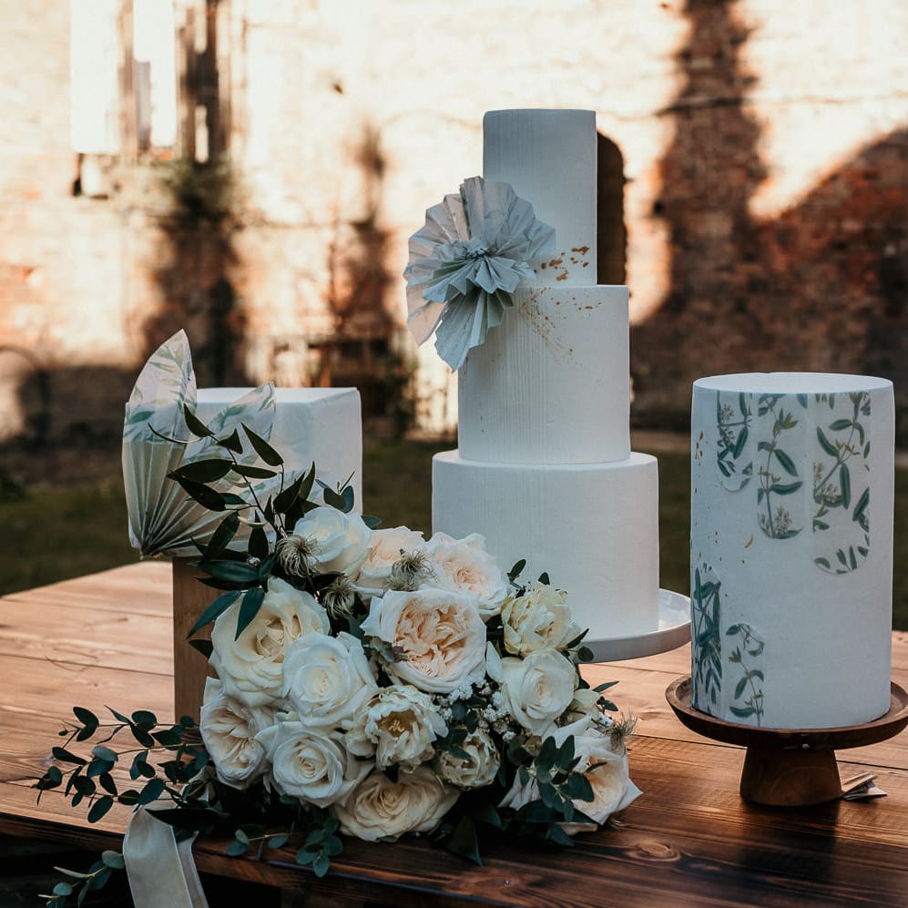 Three buttercream wedding cake designs with square and round layers and floral decor 