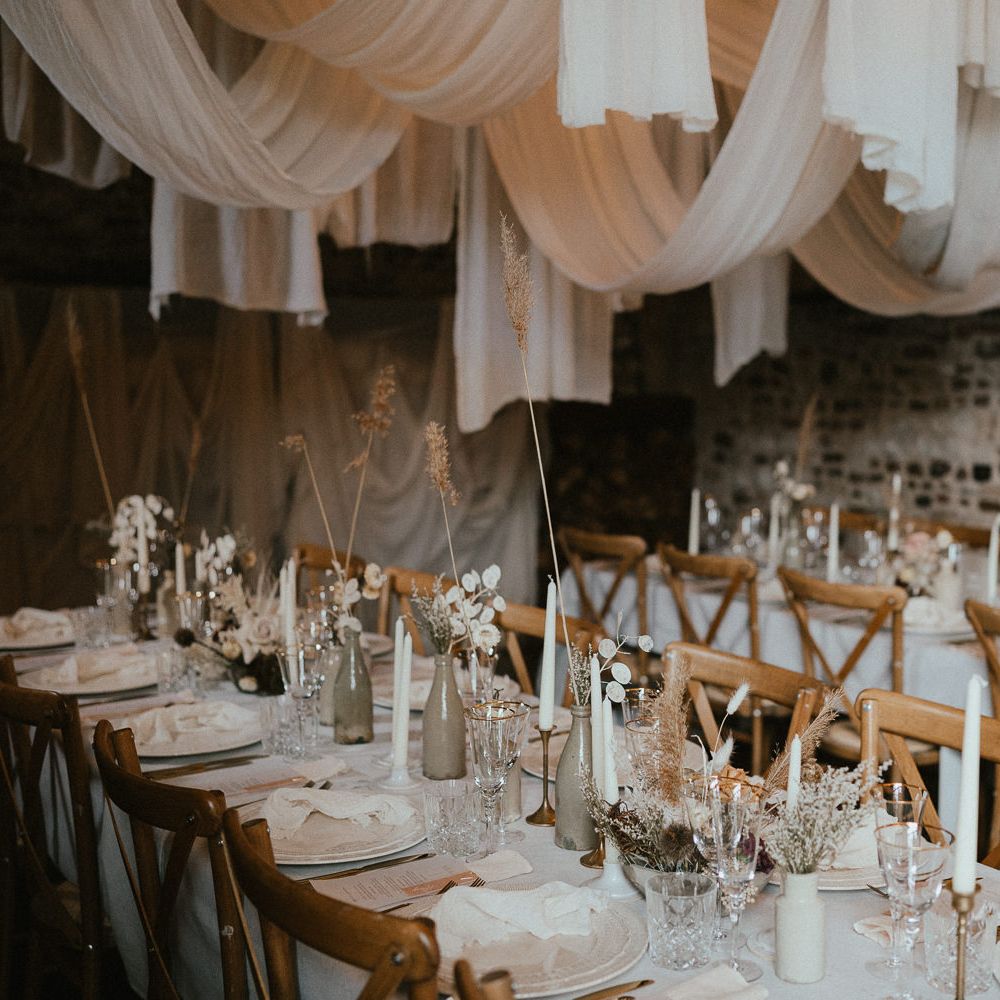 elegant place settings with ornate tableware, gold rimmed glassware and neutral floral centrepiece decor 