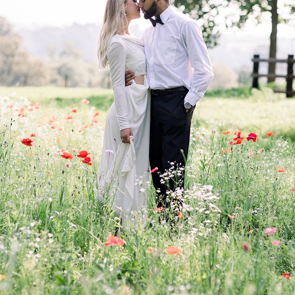 Romantic bride and groom portraits in a poppy meadow at country house wedding venue 