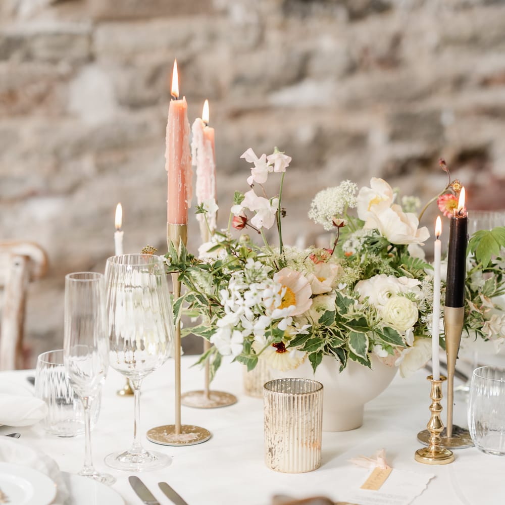 Mercury glass votives, pink taper candles and an elegant floral centrepiece 