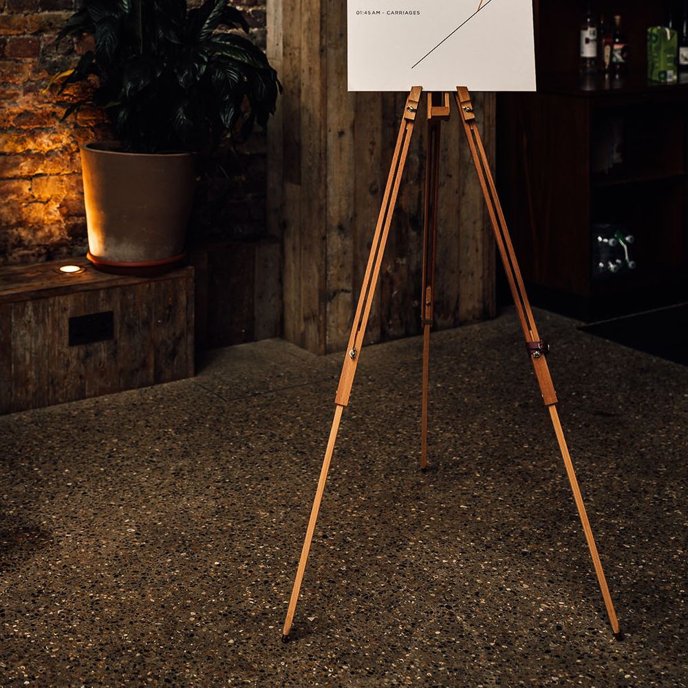 Order of the day wedding sign o a wooden easel at 100 Barrington wedding 