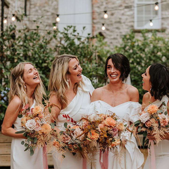 Bride in off the shoulder puff sleeve wedding dress with four bridesmaids in white one shoulder dresses