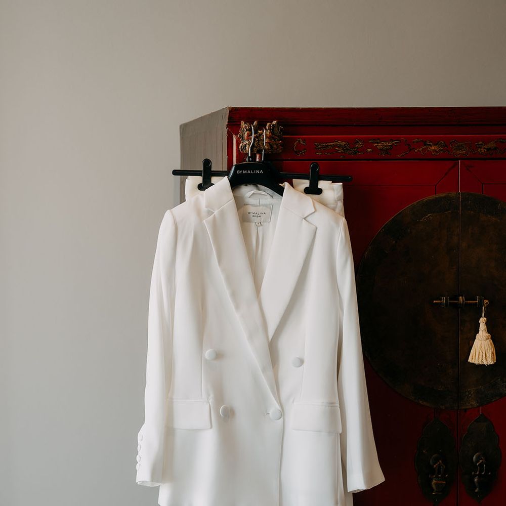 Bridal suit hung up in front of wardrobe on the morning of wedding 