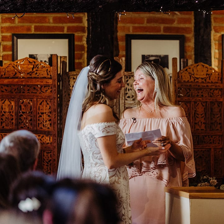 Bride and groom laugh during their wedding ceremony 