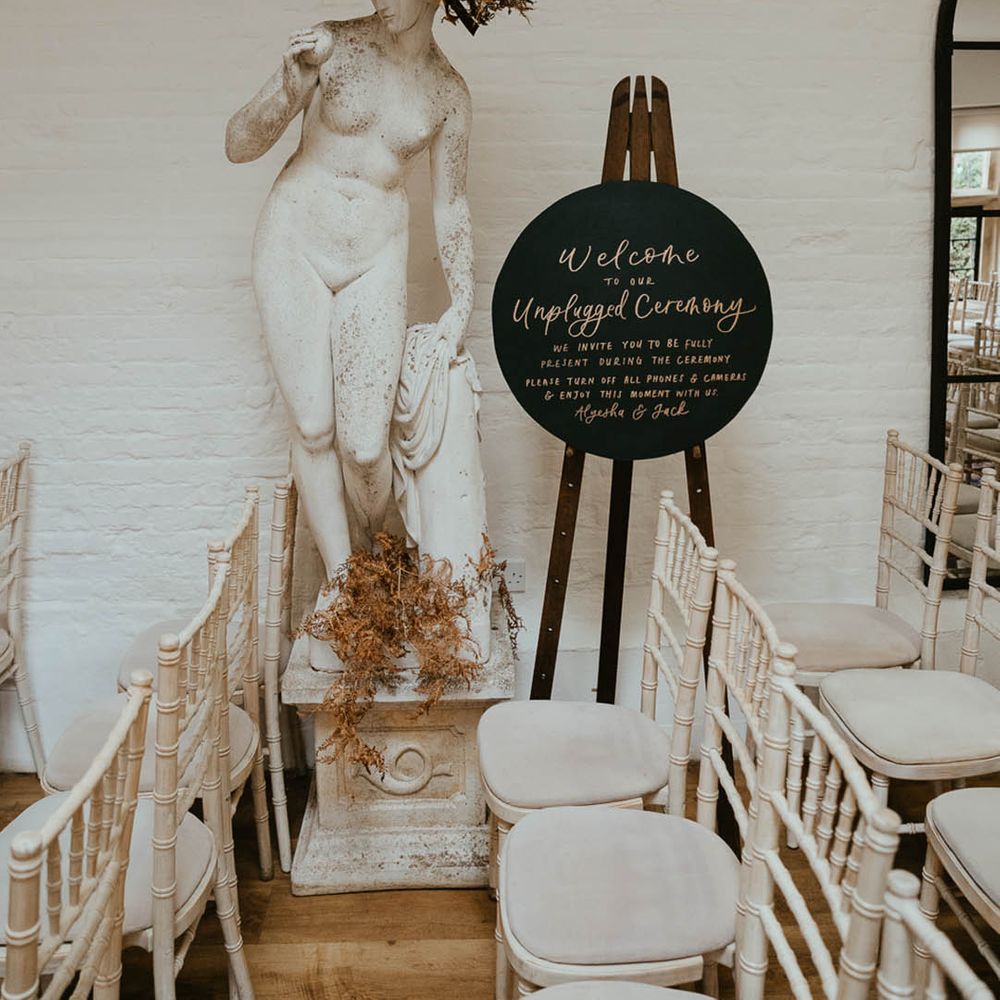 Black circular welcome wedding sign for the unplugged wedding ceremony 