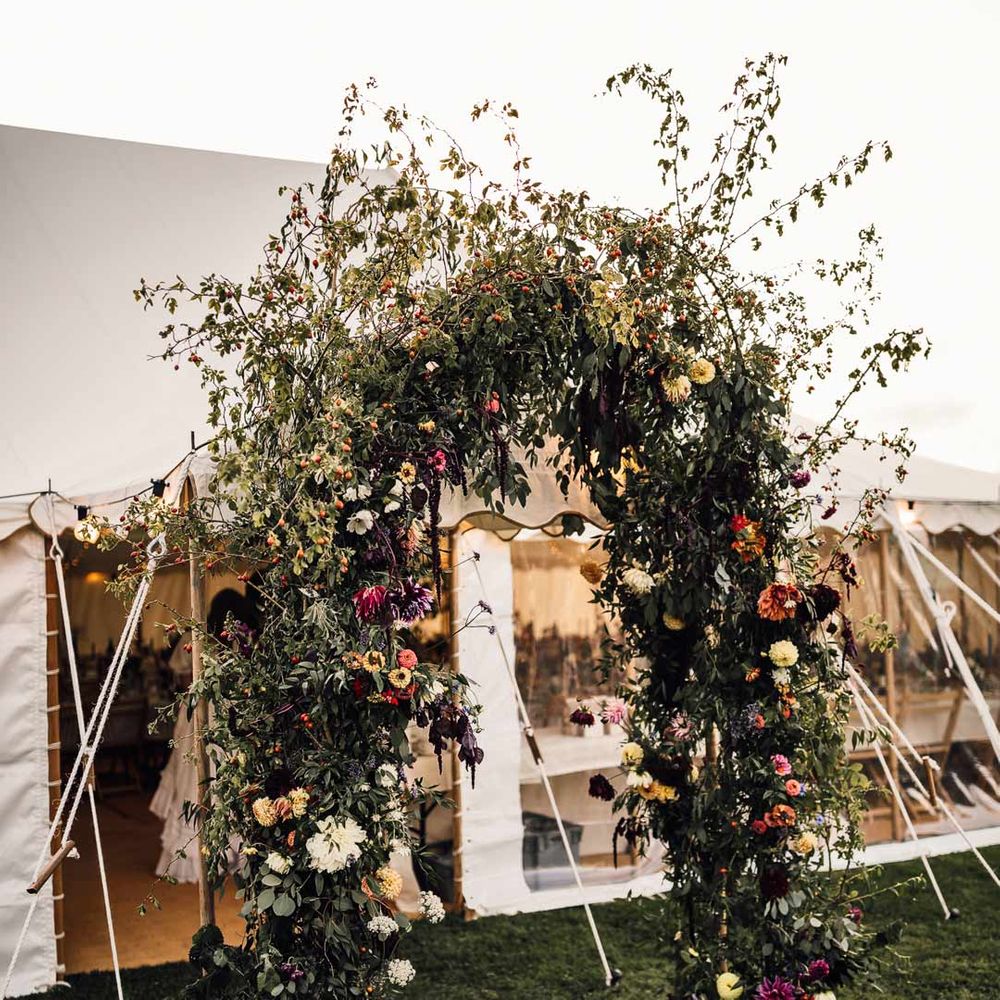 DIY fauna and floral arch outside marquee at DIY marquee wedding