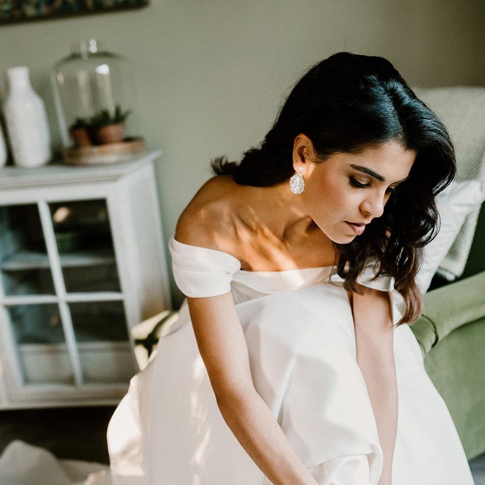 Bride puts on her studded pointed wedding shoes 