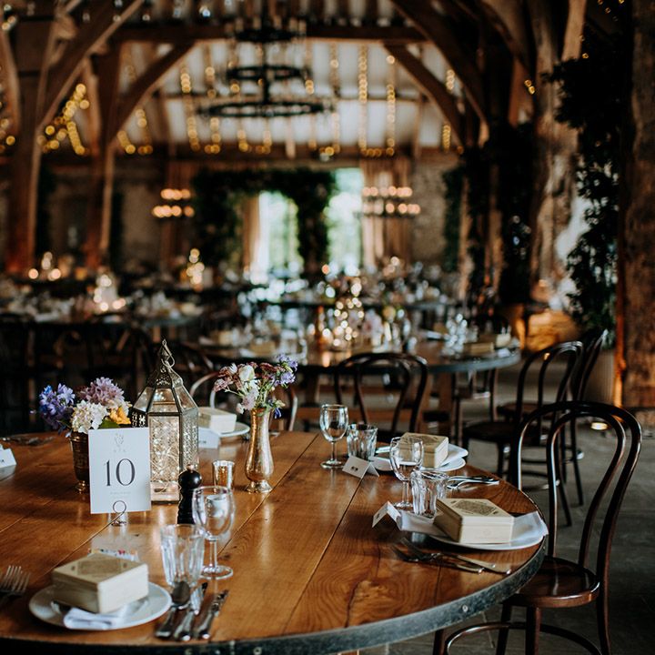 Rustic tablescape complete with small floral arrangements and fairy lights in lanterns 