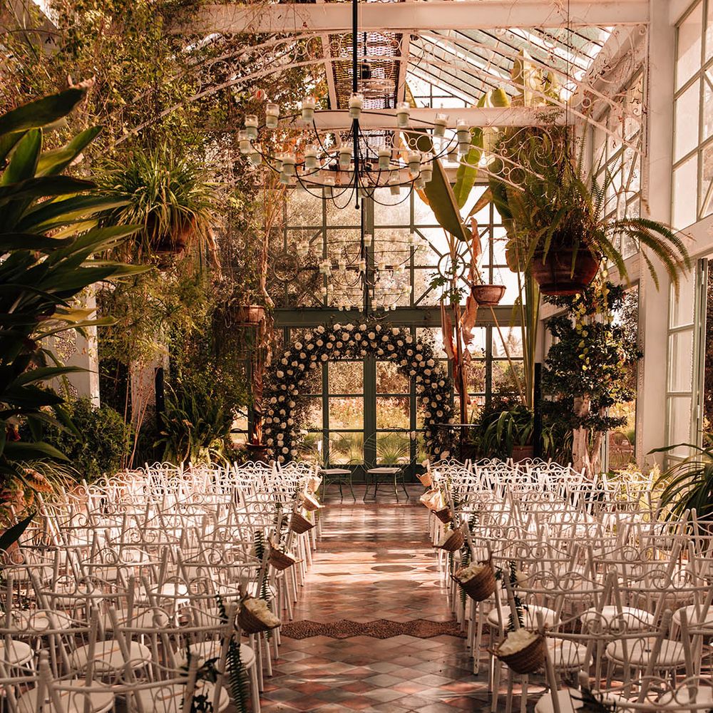 Beldi Country Club glass house wedding venue in Marrakech with white floral arch altar decoration 