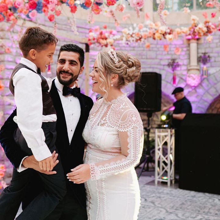 The bride and groom have their first dance with their son 