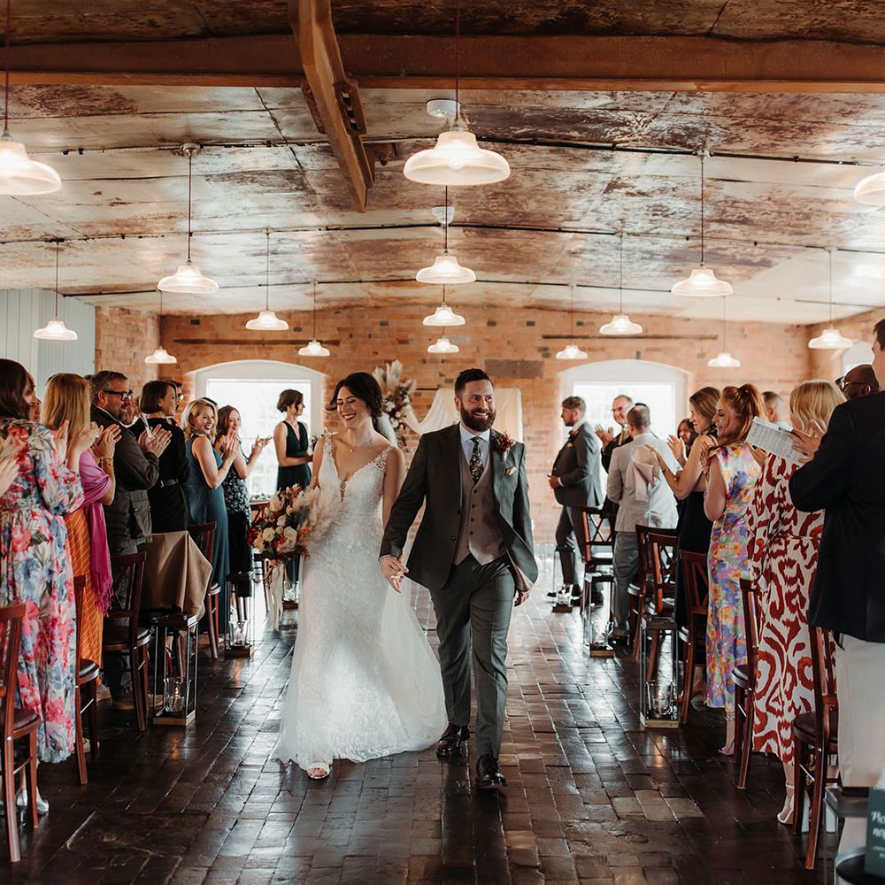 The bride and groom walk back down the aisle as a married couple at The West Mill wedding venue 