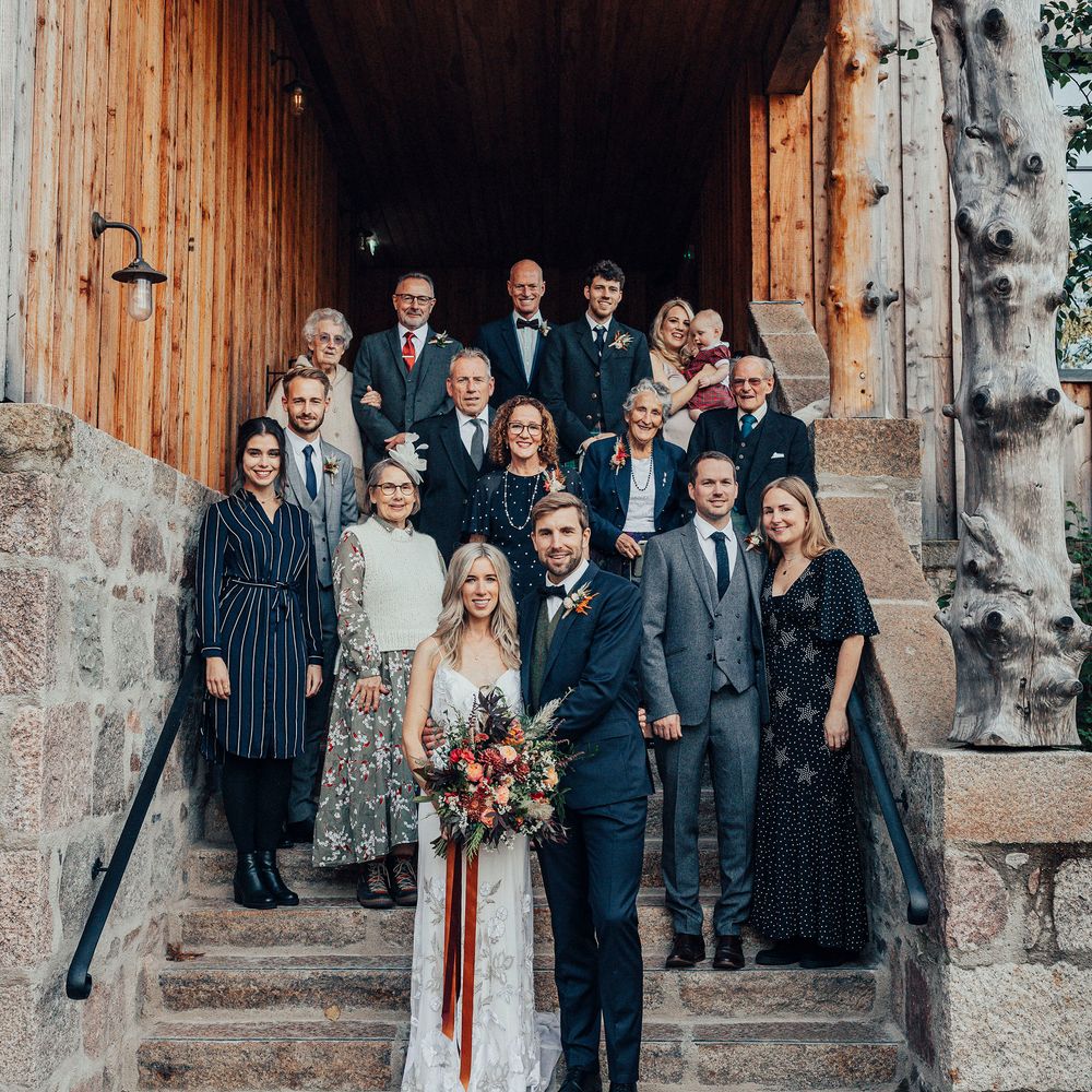 Bride & groom stand on steps with wedding party after intimate ceremony