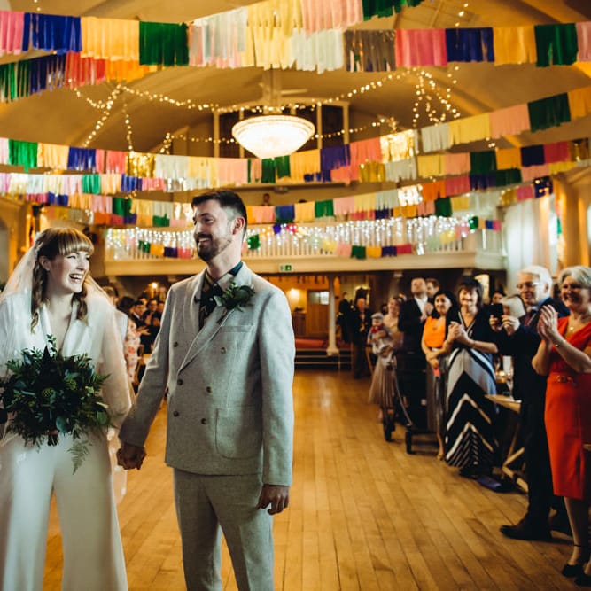 DIY wedding with colourful streamers hanging from the ceiling 