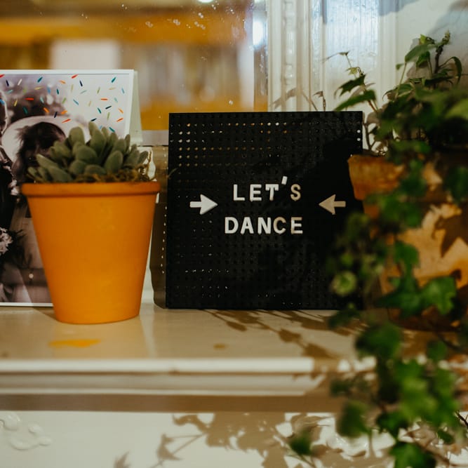 Let's dance wedding sign with foliage plant decor 