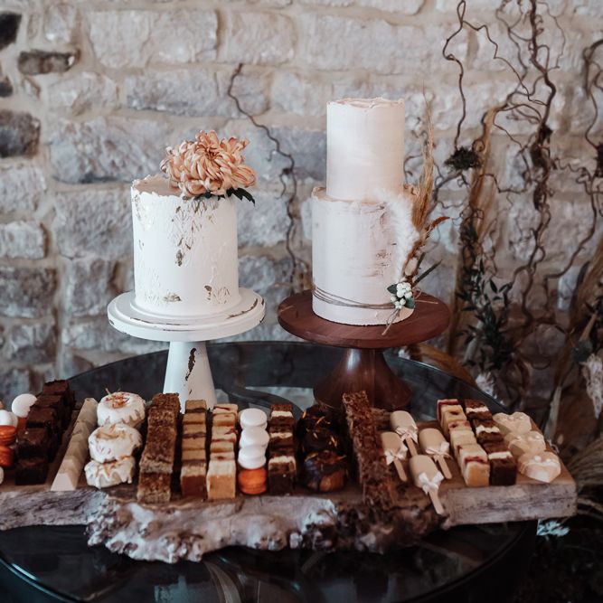Dessert table with two cakes and individual sweet treats 