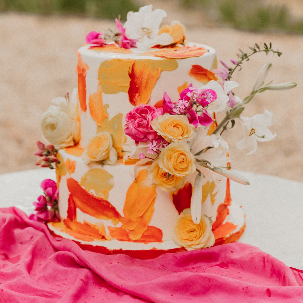 Colourful two tiered wedding cake complete with colourful floral decoration
