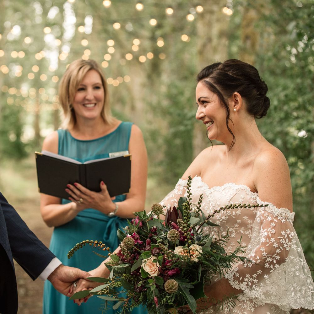 Bride & groom during vow renewal with fairy lights in the background