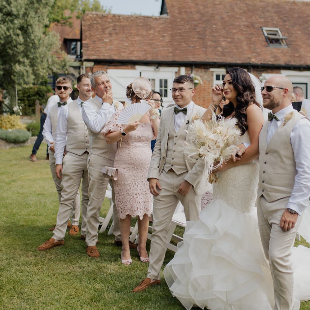 Outdoor wedding ceremony at Cooling Castle Barn with emotional bride in a fishtail wedding dress crying at the altar 