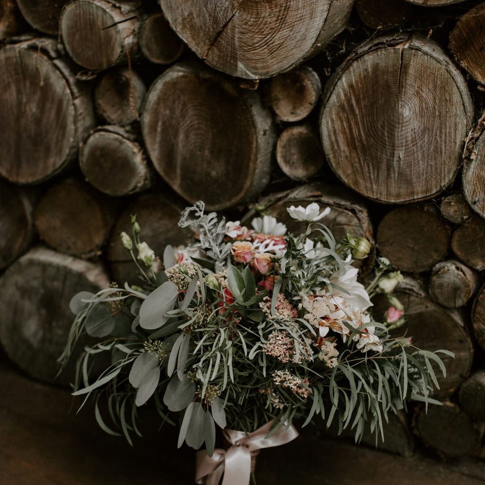 Floral bouquet complete with green foliage and tied with ribbon