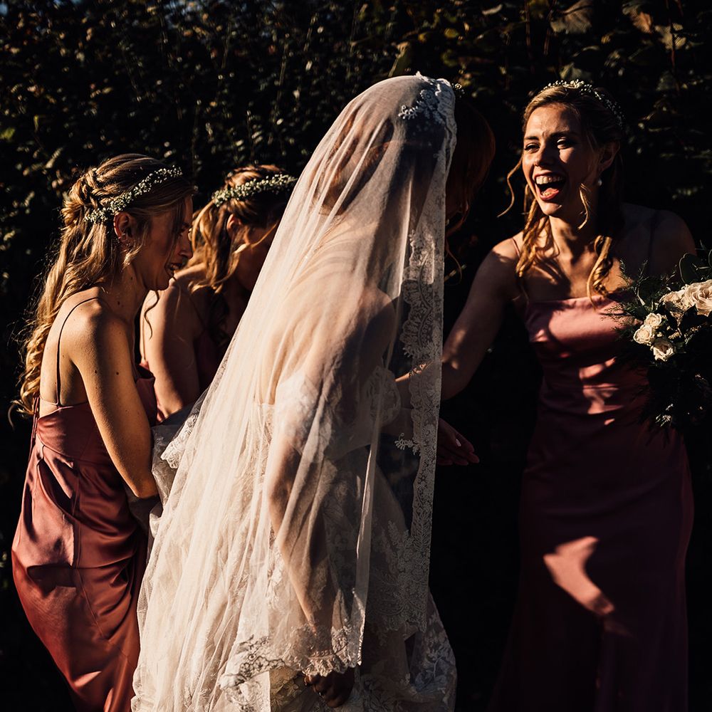 Bride walks with her bridesmaid who wear pink dresses