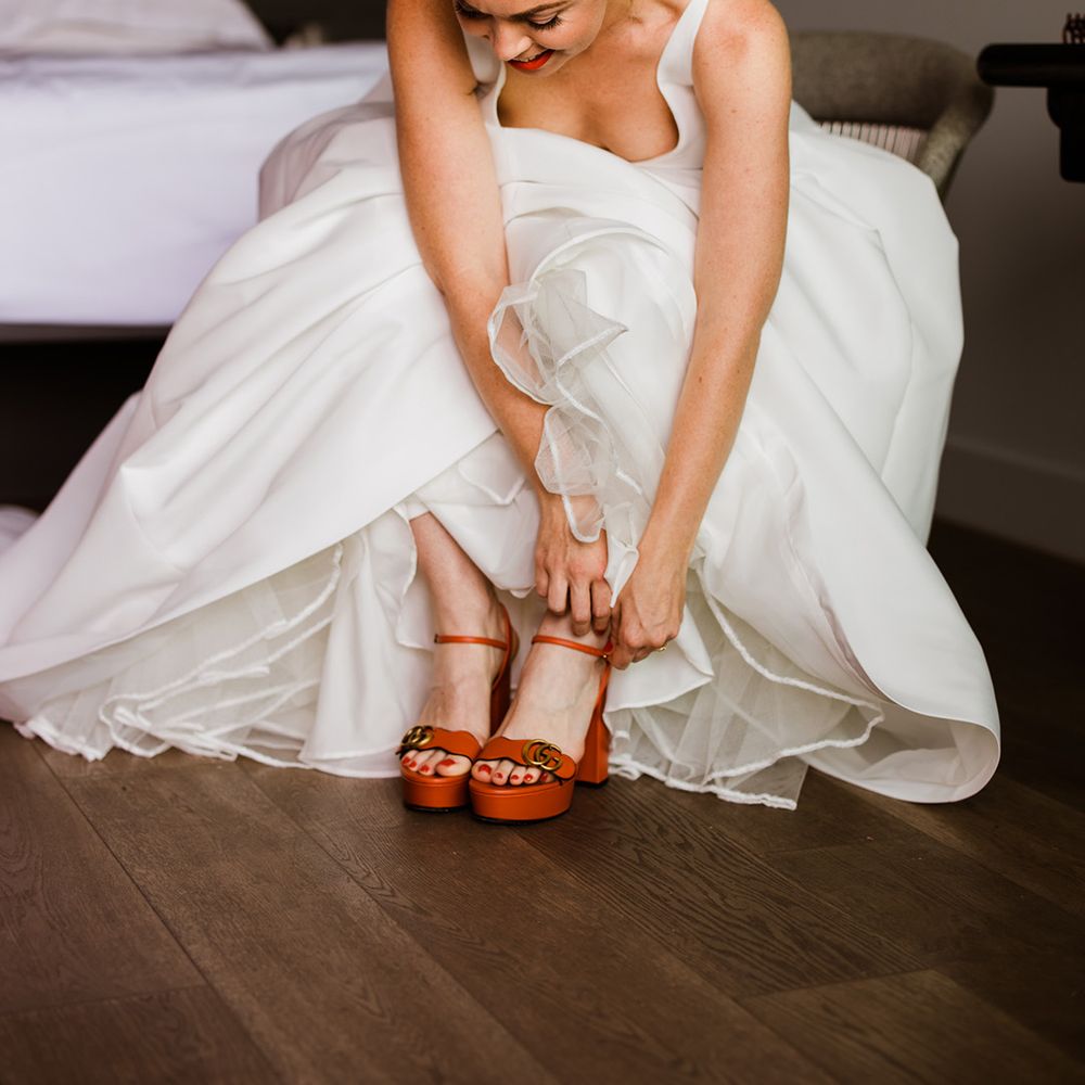 Bride does up her red platform Gucci block wedding shoes for her big day