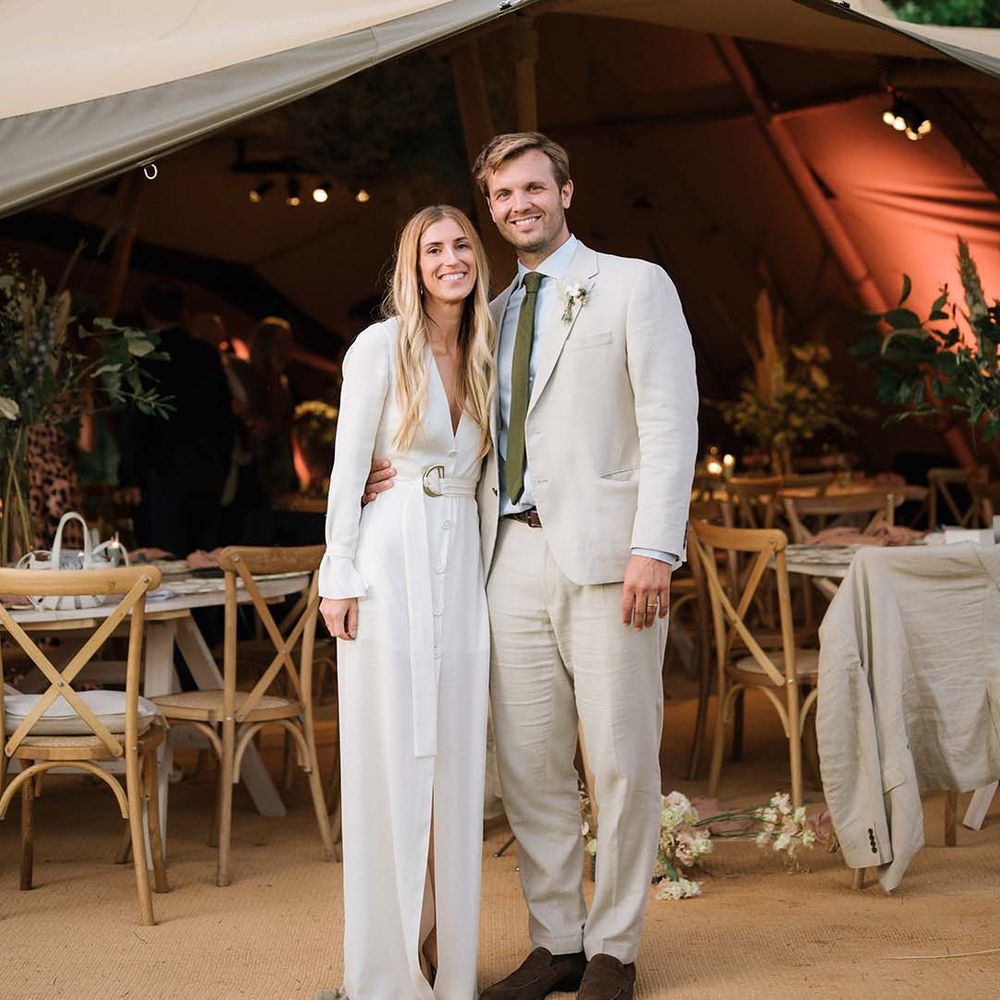 Bride in relaxed Bon Bride wedding dress with buttons and front slit with groom in front of the Buffalo Tipi