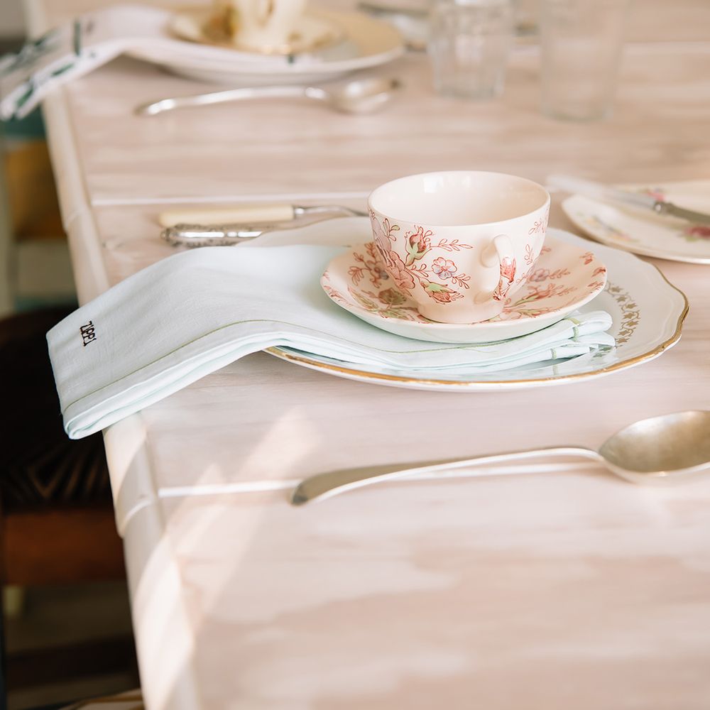 Fine china wedding table setting with flower cup and saucer with personalised napkin