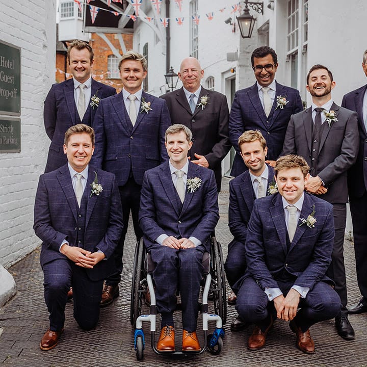 Groom with the groomsmen and wedding guests all in blue or grey wedding suits