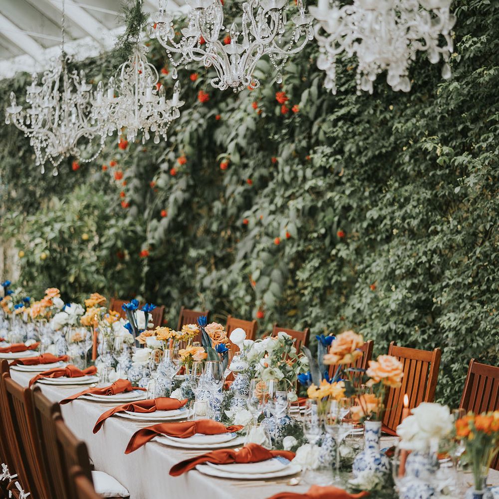 Chandelier decor with orange and blue flowers and tablescape 