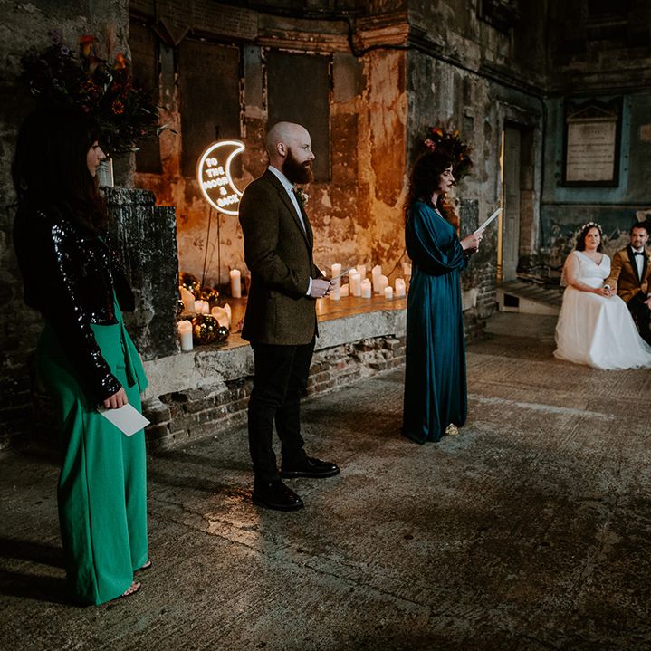 Bridesmaid in green satin dress does wedding reading during ceremony at The Asylum Chapel, a unique wedding venue in London