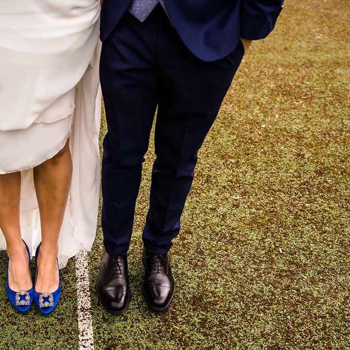 Bride wears blue Manolo Blahnik heels beside groom in Loake wedding shoes