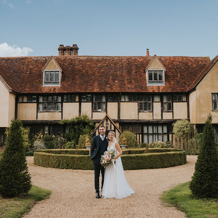 Dove Barn Weddings venue in Suffolk with the bride and groom standing in front of the wedding venue 