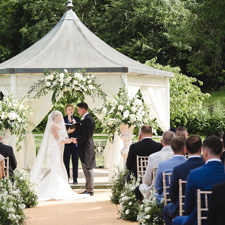 Outdoor wedding ceremony in a gazebo at The Manor House, Castle Combe wedding venue 