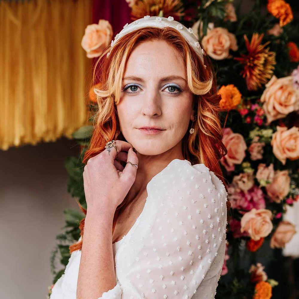 Bride in three quarter length puff sheer sleeve wedding dress with delicate polka dot overlay and square neck and white 3D applique polka dot headband and silver wedding jewellery at Northern Monk Refectory Leeds  