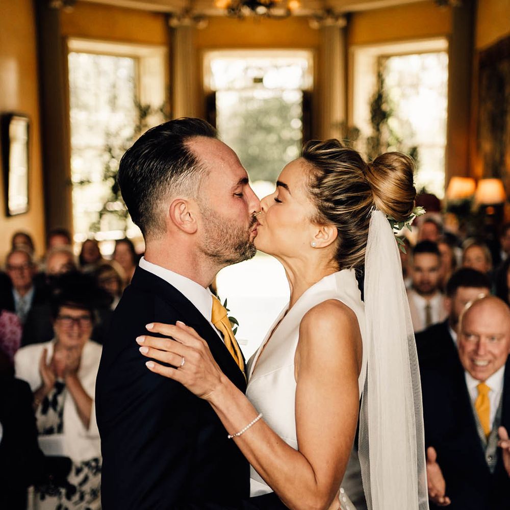 The bride and groom share their first kiss as a married couple 
