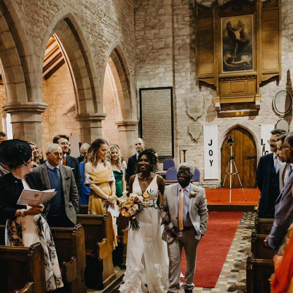 Bride in v neck sleeveless wedding dress with 3D floral applique train walking with her father at Brinsop Court wedding venue church 