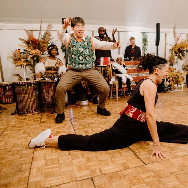 Bride in black bridal jumpsuit doing the splits during last dance wedding song at Broadfield Court wedding