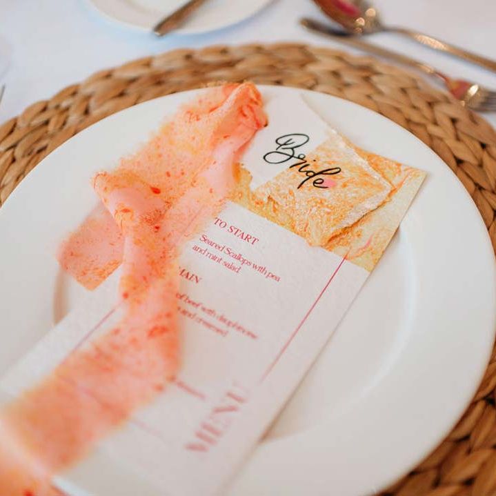 Orange and pink wedding stationery and ribbon on burlap wedding place mat at Merriscourt wedding