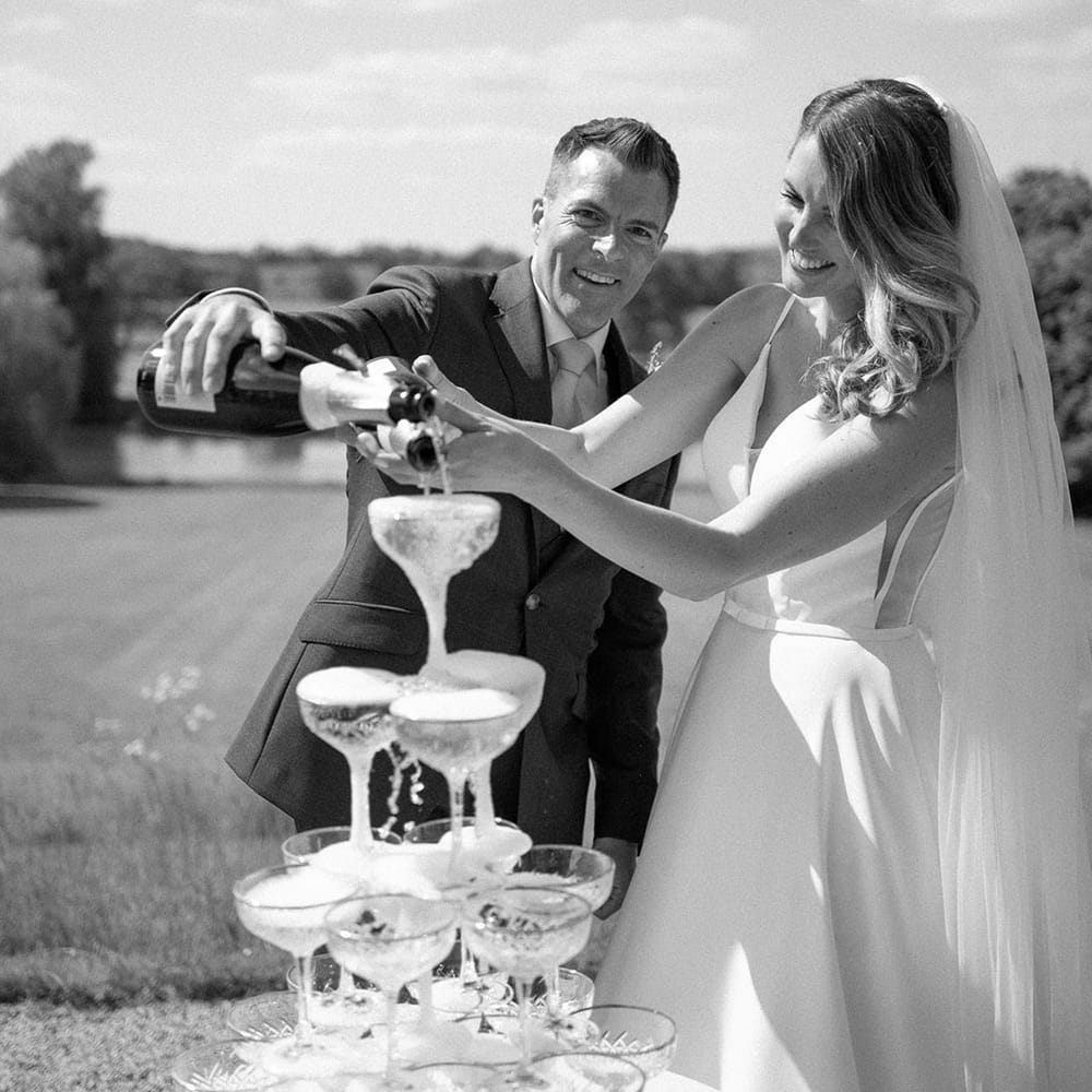 Bride and groom with their epic champagne tower wedding decoration 