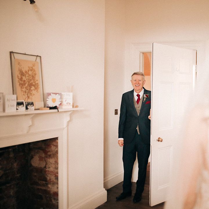 Father of the bride in a navy and grey wedding suit with red details 