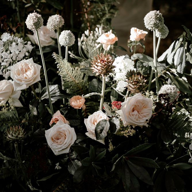 blush pink and foliage wedding flower arrangements in the woods