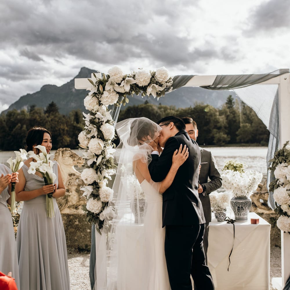 Bride and groom kissing at the altar with white flower in blue and white Chinese pottery 