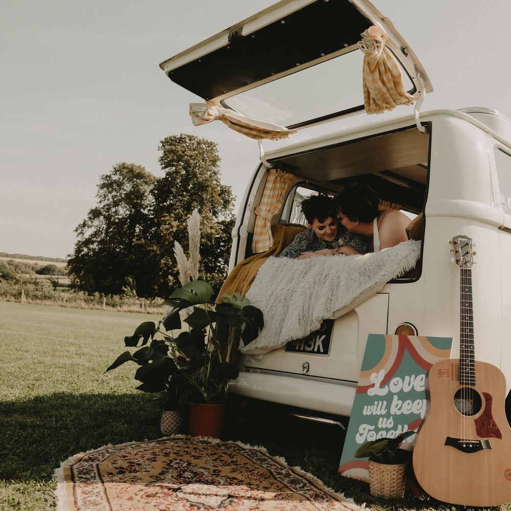 Brides sitting together in a camper van at LGBT wedding 