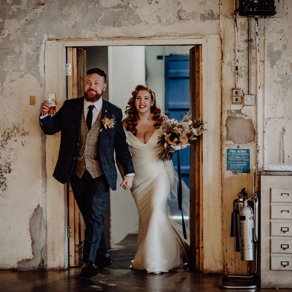 Bride with vintage wedding hair and groom entering their micro wedding reception 