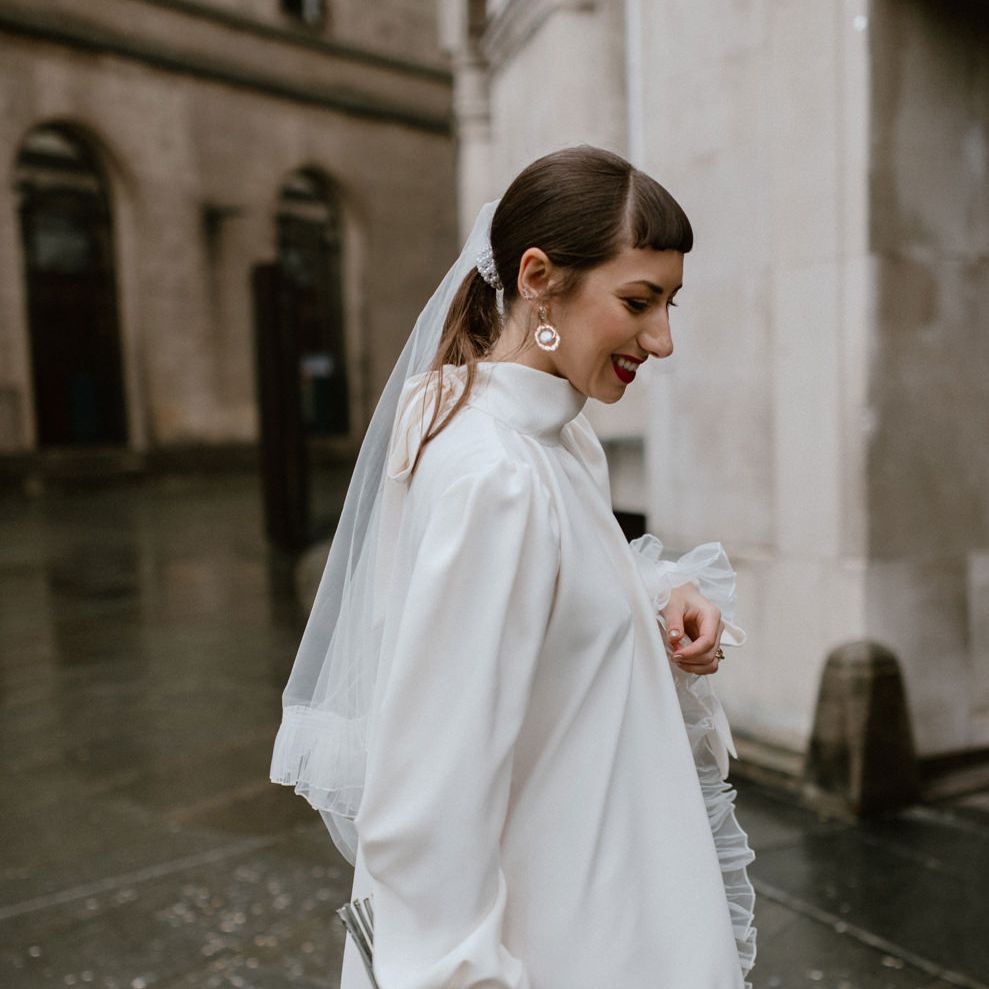 Loose fitting silk wedding dress with gathered hem, high neck and long sleeves 